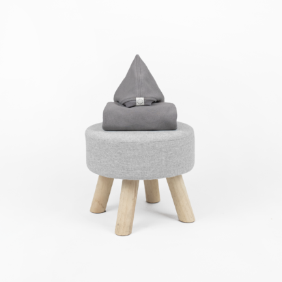 Ocean Stone shark jumpsuit with a pointy hood displayed on a little chair.
