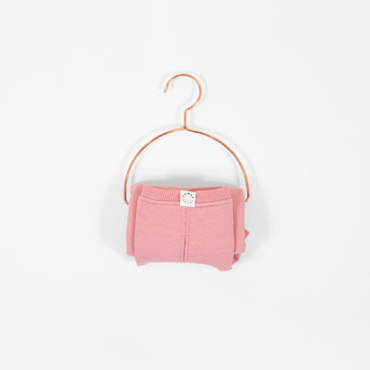 Cozy Waistcoat in color of Flamingo Pink displayed on a hanger.