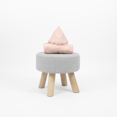 Cotton Candy dog clothing with a pointy hood displayed on little chair.