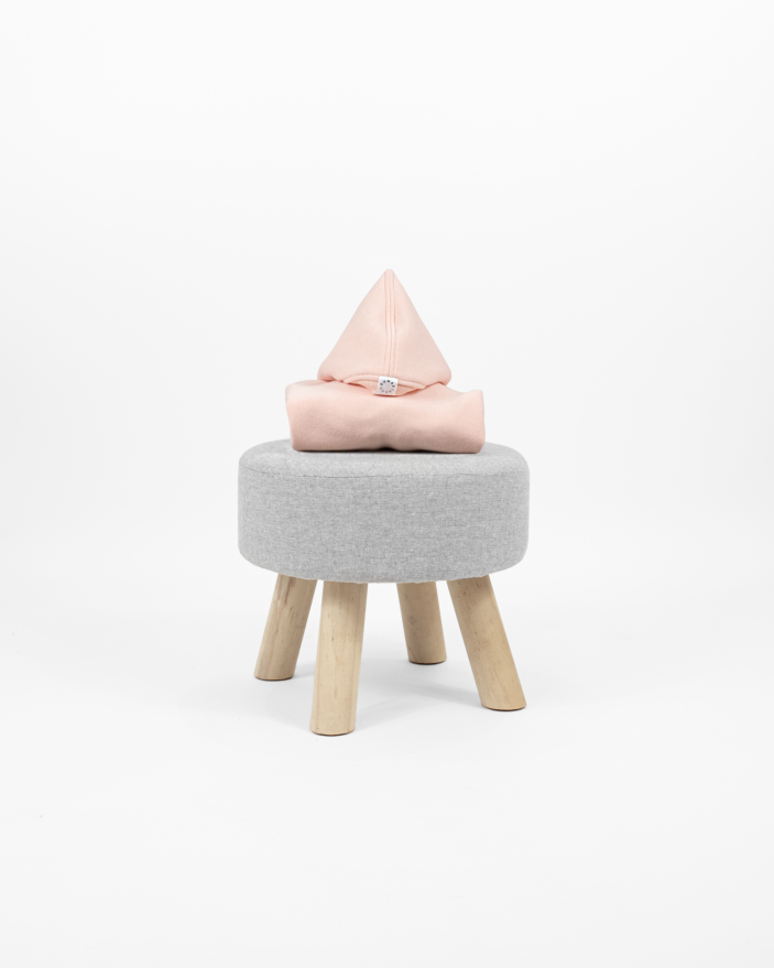 Cotton Candy dog clothing with a pointy hood displayed on little chair.