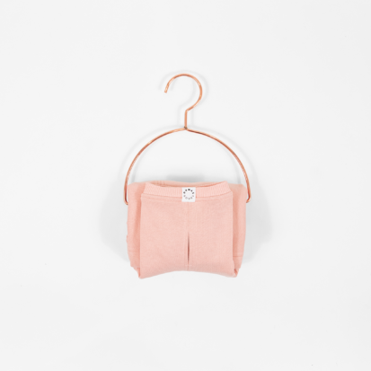 Cozy Waistcoat in color of Pale Coral displayed on a hanger.