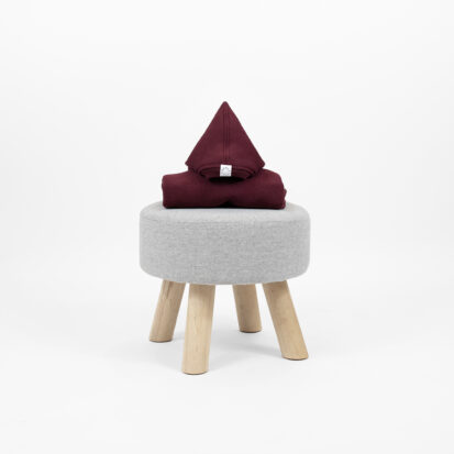 Primitivo shark jumpsuit with a pointy hood displayed on a little chair.